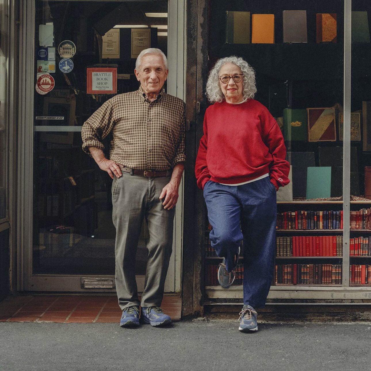 A man and woman standing on the street in front of a bookstore.
